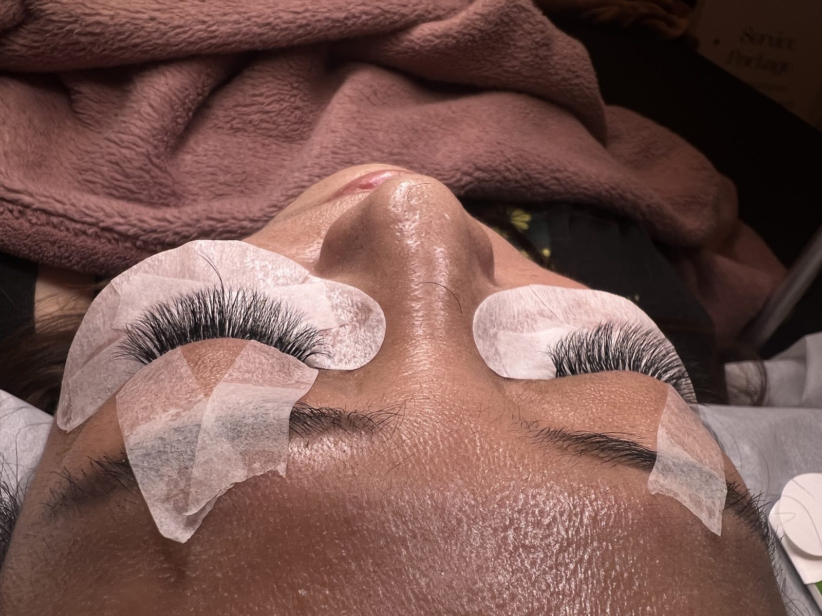 A client mid-treatment with under-eye pads in place
